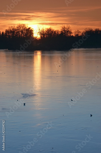 Sonnenuntergang im Winter   ber einem Eissee