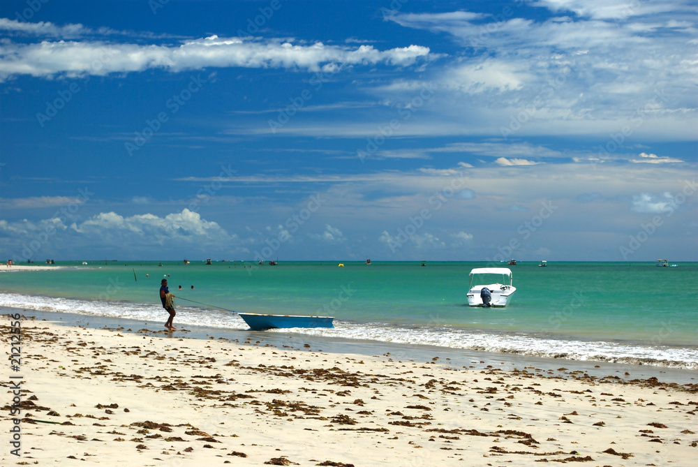 Fisherman in a crystalline green sea in Alagoas, Brazil