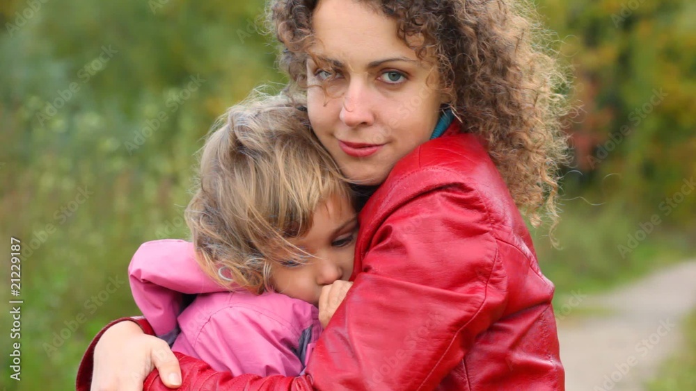 young woman hugs little girl in the wind outdoors young woman hugs little girl in the wind outdoors