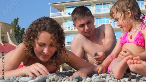family fingering stones in pebble beach, hotel in background