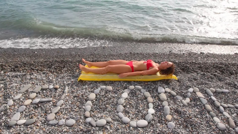woman lying on mattress, WELCOME stone inscription in foreground woman lying on mattress, WELCOME stone inscription in foreground