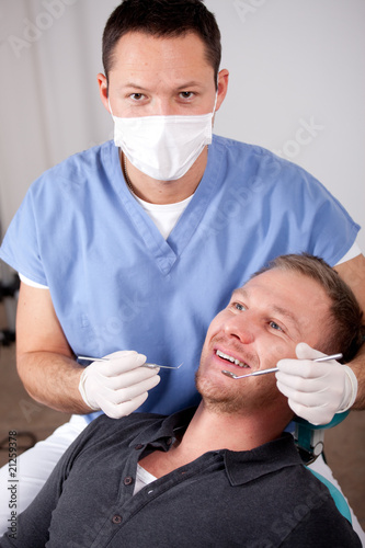 Handsome young man visiting dentist for dental checkup