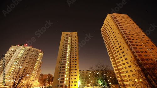 The star sky moves over many-storeyed houses, night. Time Lapse.