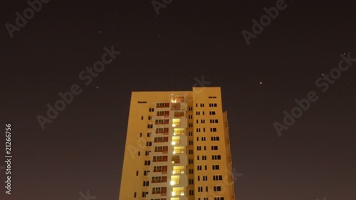 The star sky floats over many-storeyed house, night