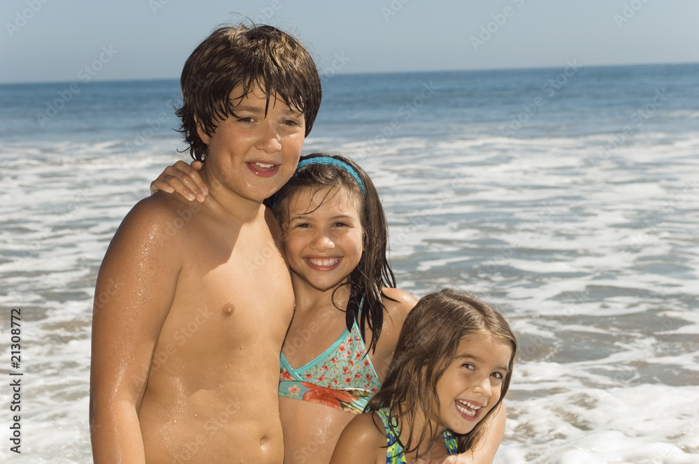 children in swimwear standing together by sea children in swimwear standing together by sea