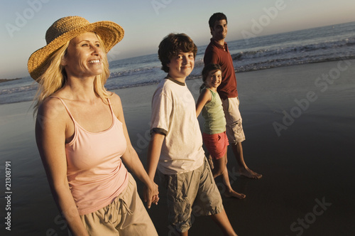 family walking on beach at dusk