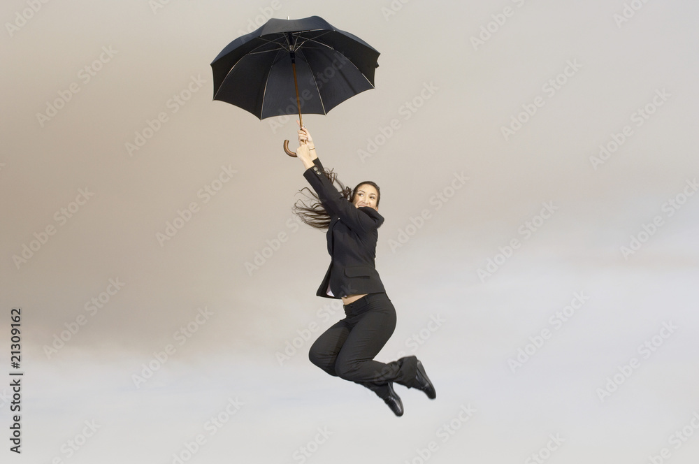 woman jumping with umbrella mid-air outdoors woman jumping with umbrella mid-air outdoors