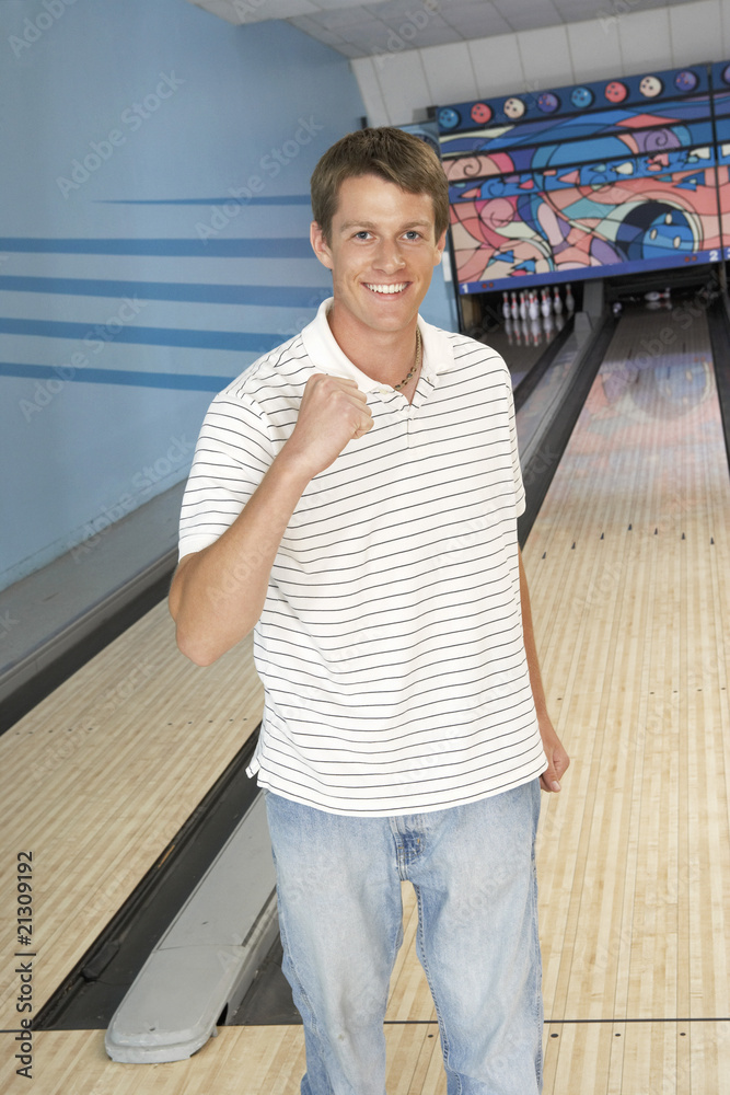 Fototapeta premium young man at bowling alley celebrating portrait
