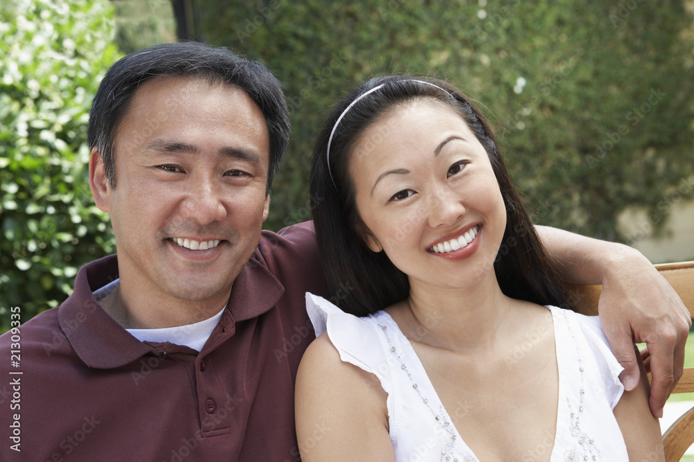 couple sitting on bench in garden couple sitting on bench in garden