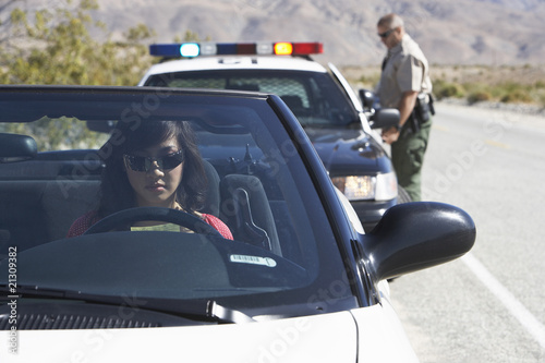 Bild auf Leinwand women sitting in car being pulled over by police officer