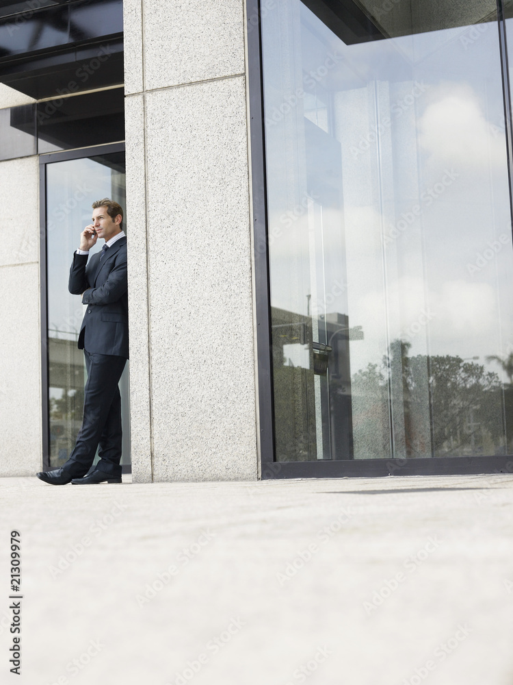 Fototapeta premium businessman using mobile phone outside office building