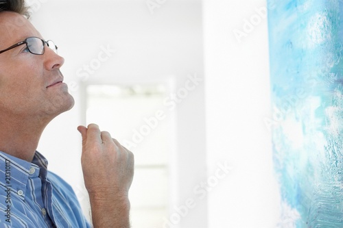 Фотография man observing painting in art gallery
