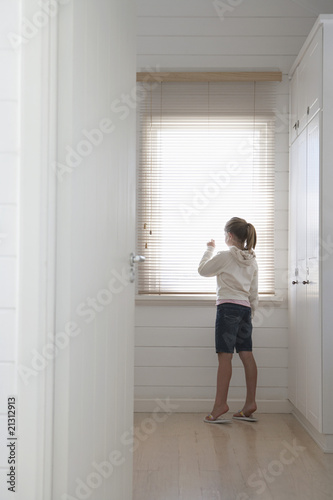 Free Download young girl peering through blinds standing at window full length - GFXLoad