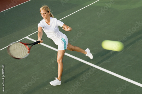 tennis player hitting tennis ball with forehand
