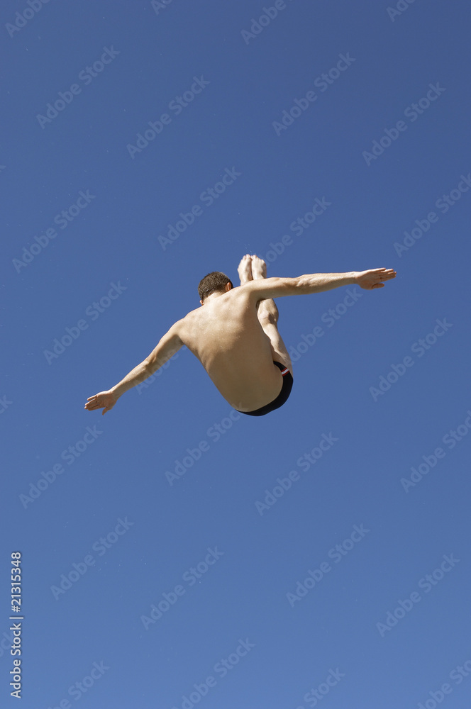 man diving in pike position mid air