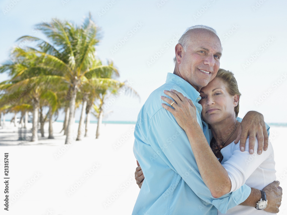 Obraz premium senior couple on beach embracing on tropical beach