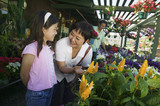 grandmother with granddaughter looking at plants in nursery