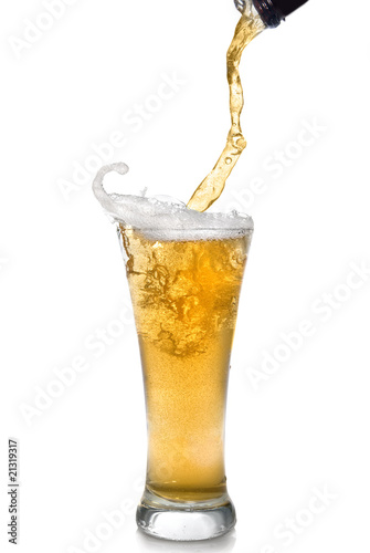 Фотография Beer pouring from bottle into glass isolated on white