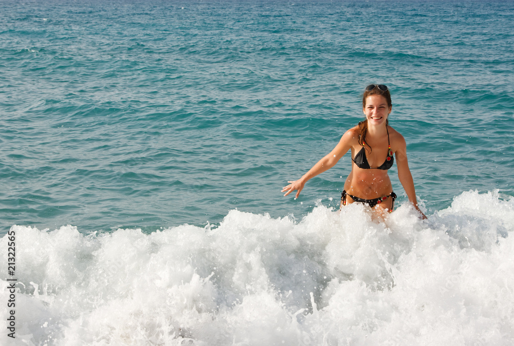 Young woman playing with waves on the beach Young woman playing with waves on the beach