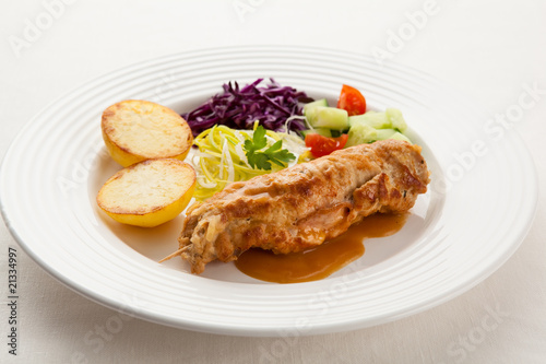 Roasted stuffed pork chop with chips and vegetables