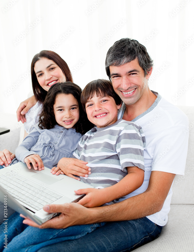 Jolly family using a laptop sitting on sofa Jolly family using a laptop sitting on sofa
