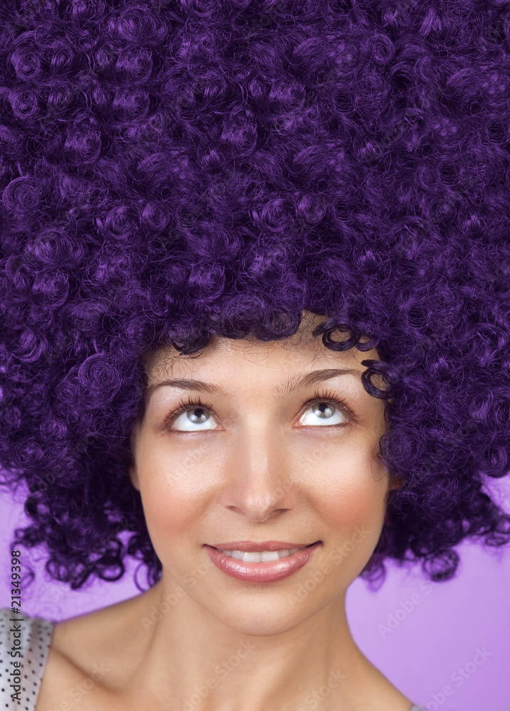 Woman with curly hair or wig looking up