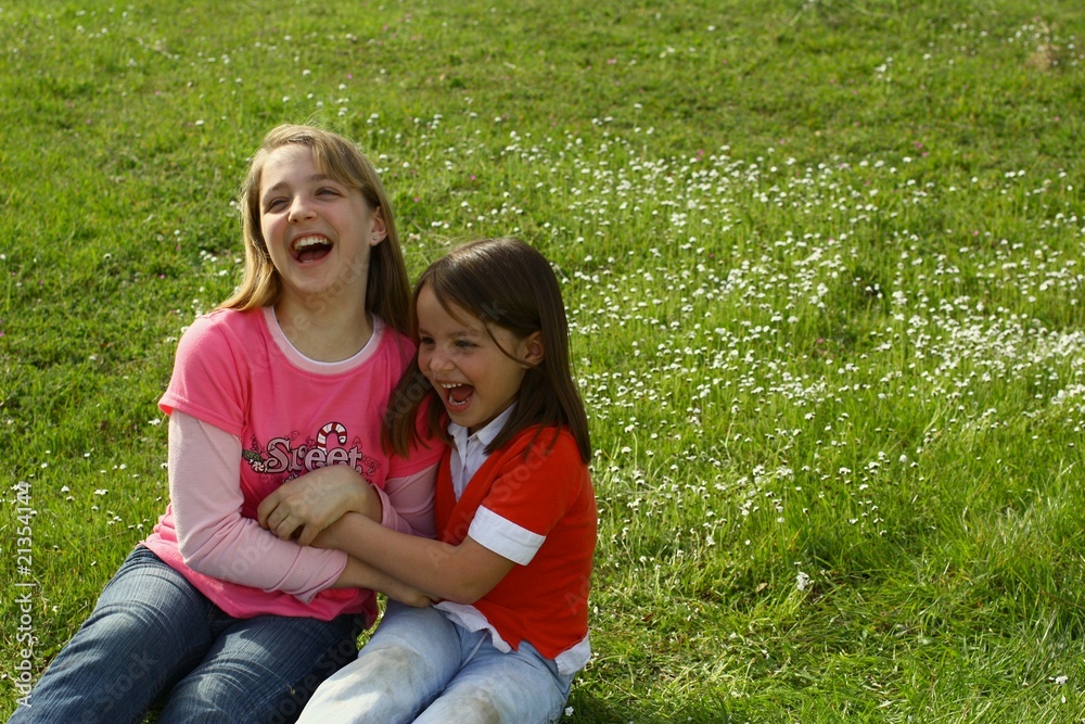 Two sisters tickling each other in the springtime weather. Two sisters tickling each other in the springtime weather.