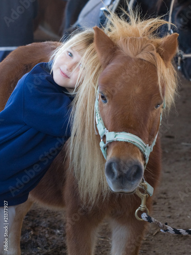 bambina che abbraccia un pony