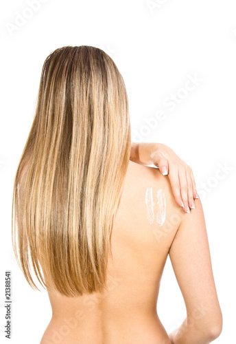 Causasian blonde woman creaming her back