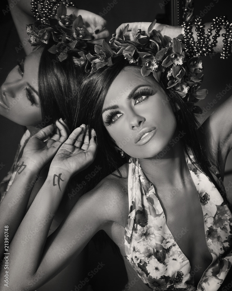 Naklejka premium Young beautiful brunette posing at mirror, black-white version