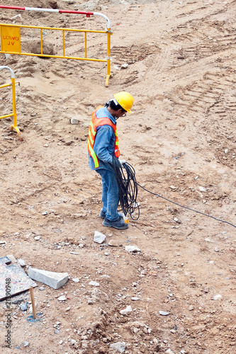 building worker at the building sitecarrying an electrical cable