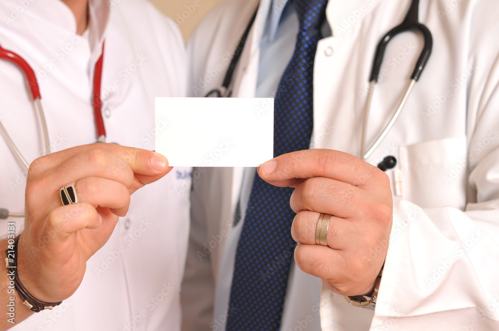 Two medical doctors holding a business card Two medical doctors holding a business card