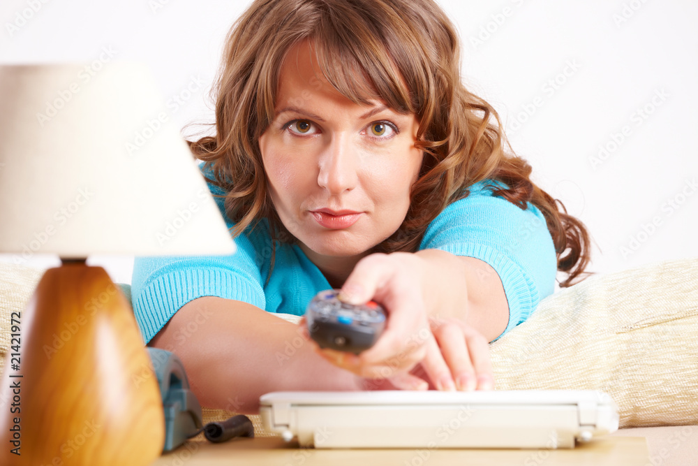 Beautiful woman laying on sofa with remote controller Beautiful woman laying on sofa with remote controller