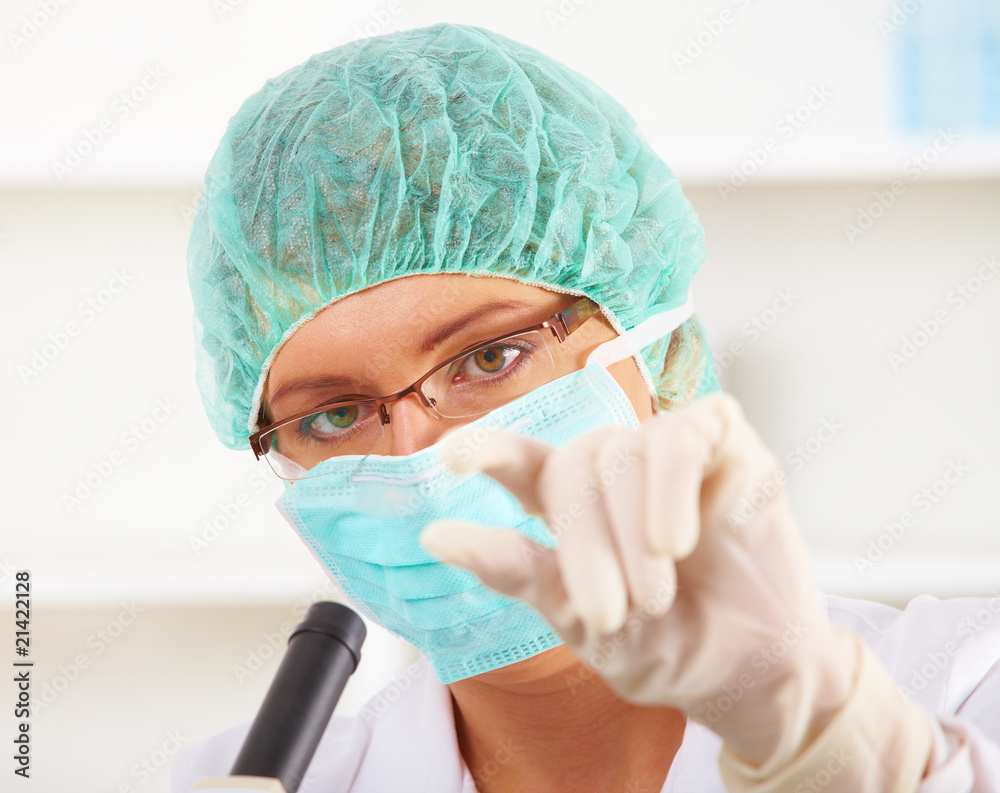 Scientific researcher using a microscope in a laboratory Scientific researcher using a microscope in a laboratory
