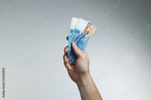 Fotografie hand holding up swiss money