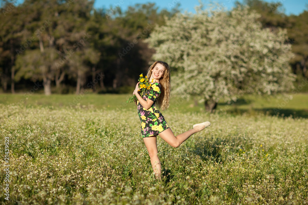 Beautiful young woman jumping in blooming meadow Beautiful young woman jumping in blooming meadow