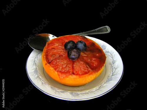 half pink grapefruit baked with brown sugar and blueberries