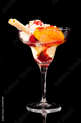 Eisbecher mit Pfirsich vor schwarzem Hintergrund