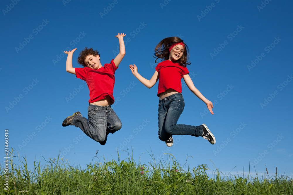 Girl and boy jumping, running against blue sky Girl and boy jumping, running against blue sky