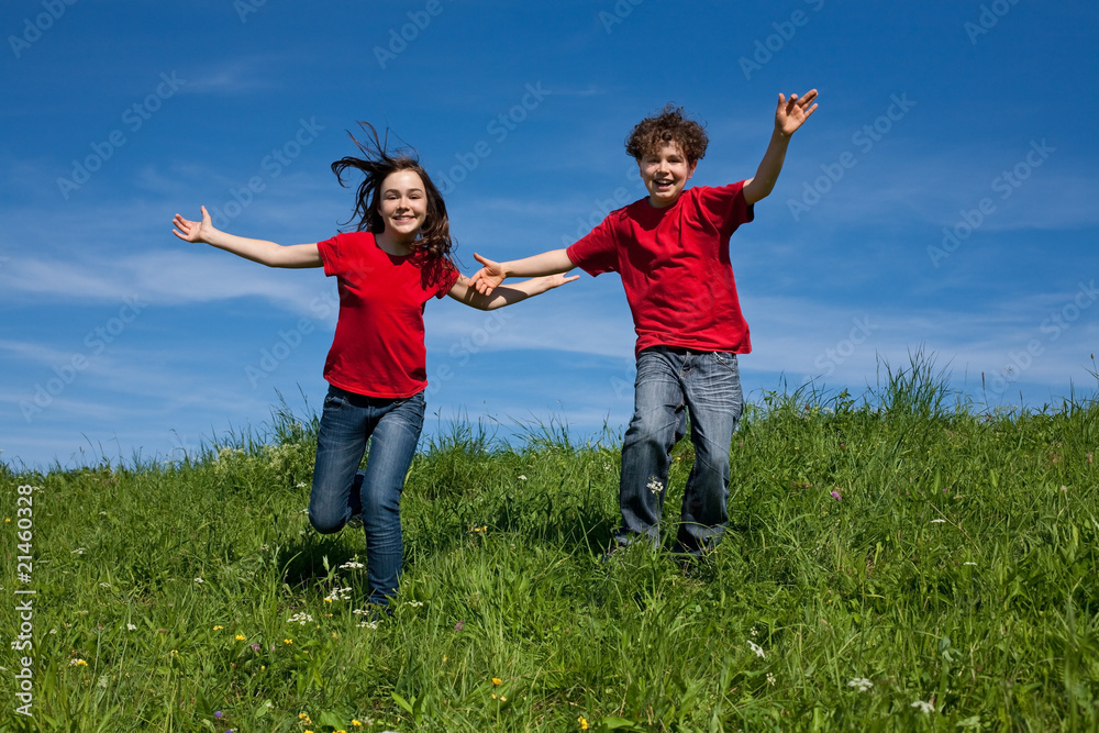 Girl and boy jumping, running against blue sky Girl and boy jumping, running against blue sky