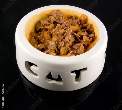 bowl of cat food on black background photo