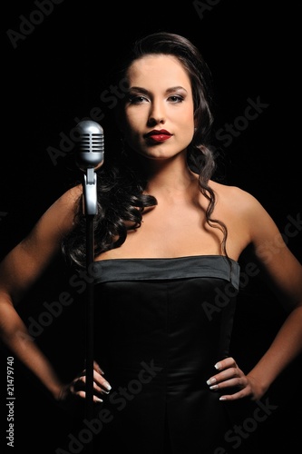 Attractive brunette woman with a retro microphone .