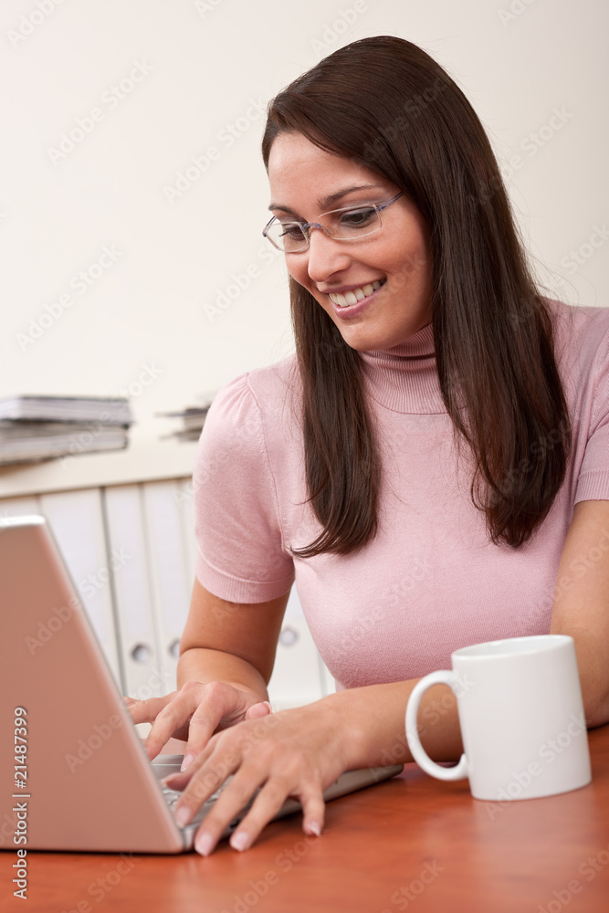 Smiling secretary with coffee and laptop at office Smiling secretary with coffee and laptop at office