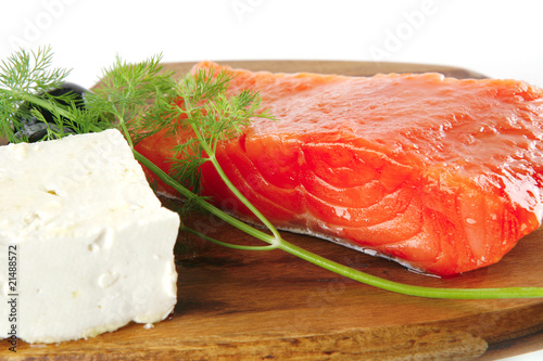 pink smoked salmon on wooden plate with white cheese
