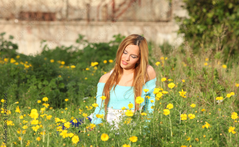 Beautiful young woman sitting in meadow Beautiful young woman sitting in meadow