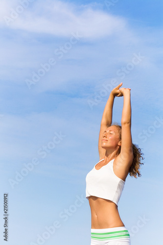 Young woman doing exercises on the beach
