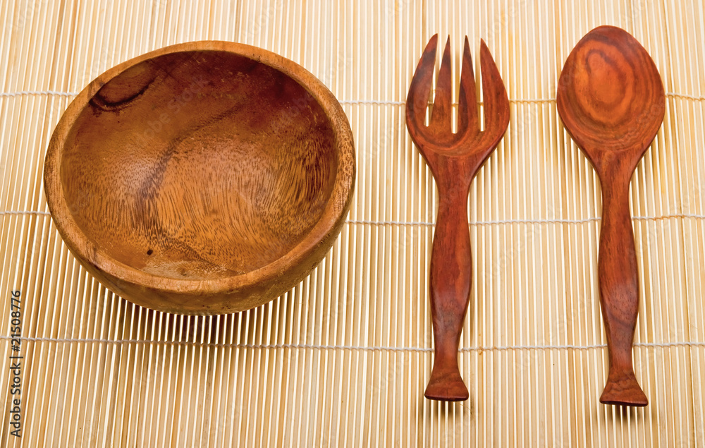 Wooden spoon, fork and basin on bamboo mat Wooden spoon, fork and basin on bamboo mat