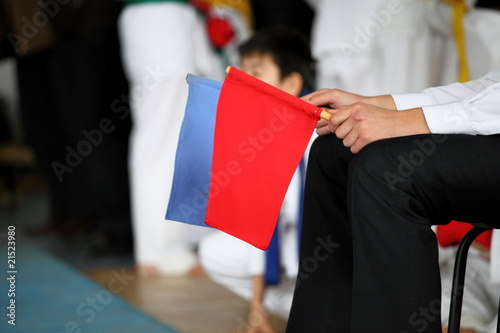judge at competitions holds a red and dark blue flag