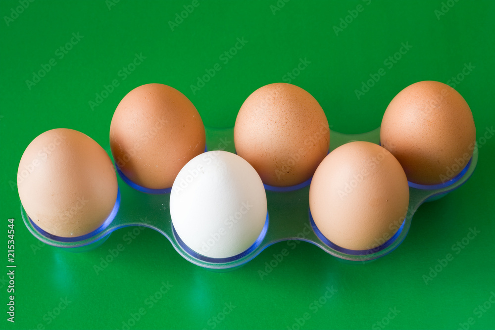 white egg in a middle of brown,on green background white egg in a middle of brown,on green background