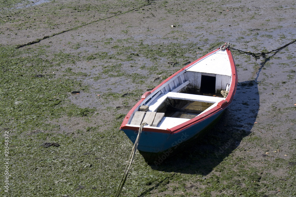 a boat stading alone in the mud